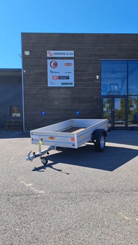 Remorque utilitaire polyvalente avec ridelles pour usage professionnel et jardinage.